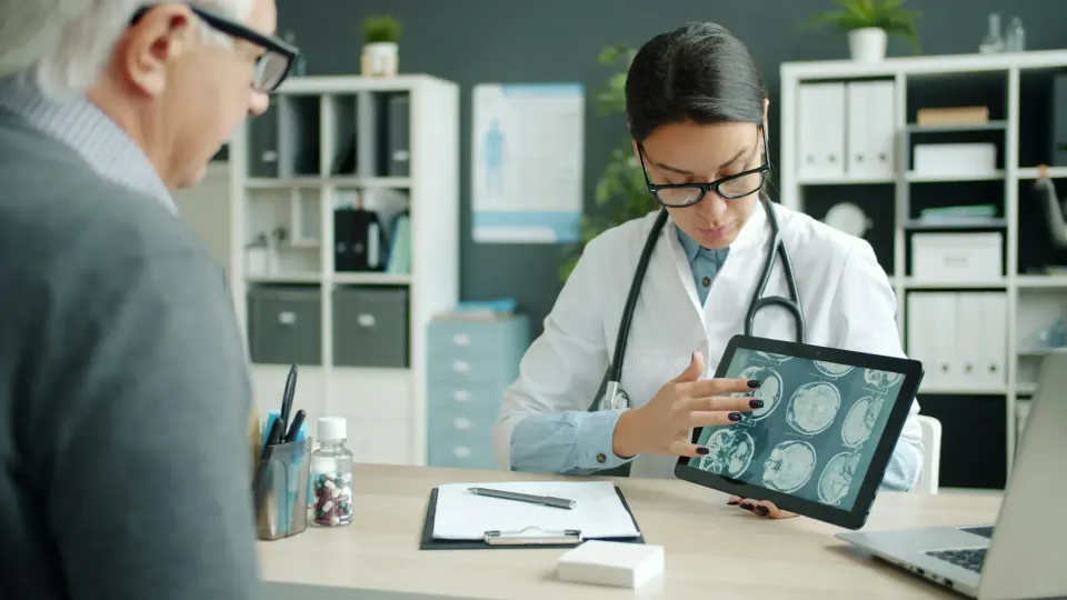 Dokter meninjau hasil pemindaian di tablet